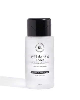 A white bottle of Skin Laundry pH Balancing Toner with a black flip-top cap. The label states "w/ antioxidants & ceramides" and indicates it's designed to "SOOTHE + REPLENISH" for "all skin types."